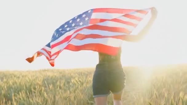 Jovem adolescente correndo com bandeira dos Estados Unidos da América EUA ao pôr do sol. Movimento lento
 - Filmagem, Vídeo