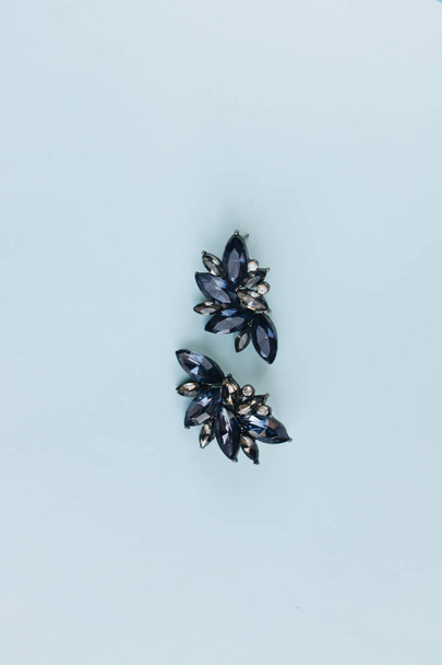 paires de boucles d'oreilles avec des gemmes bleues sur fond bleu
 - Photo, image