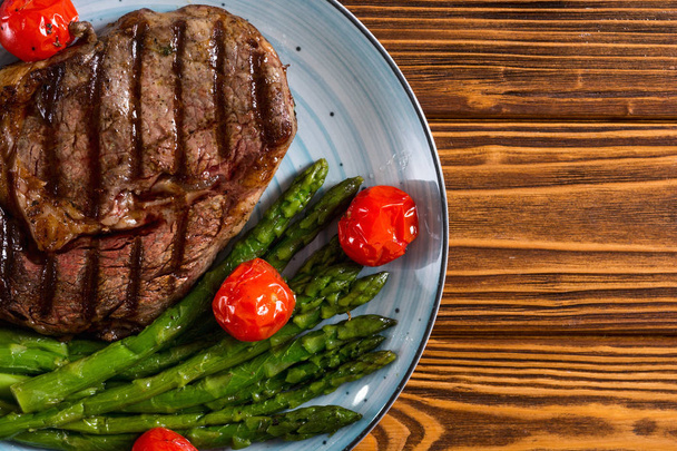Hovězí steak z grilovaného hovězího masa s třešňovou rajčaty a chřestem - Fotografie, Obrázek
