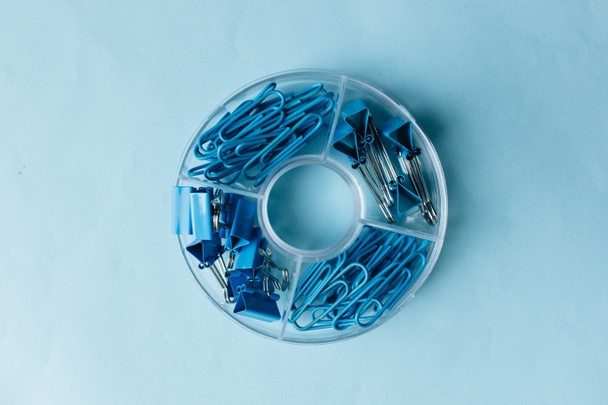 pile of blue paper clips in organiser on blue background - Zdjęcie, obraz