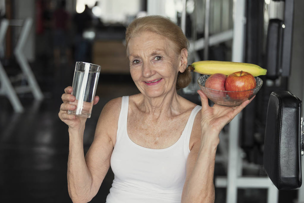 Vanhempi nainen syö terveellistä kasvis- ja juomavettä
.  - Valokuva, kuva