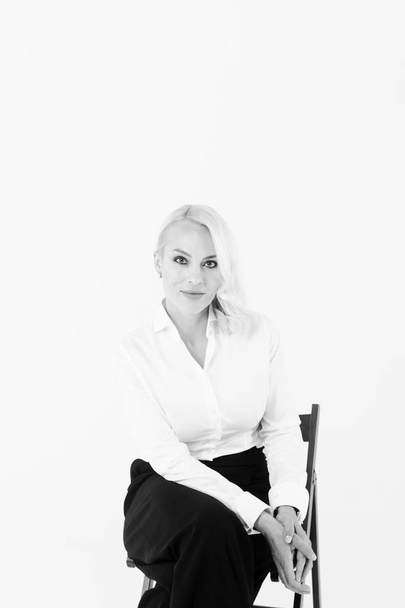 Portrait of a blonde woman in a white shirt and black pants - Zdjęcie, obraz