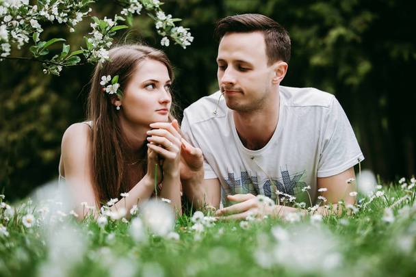 Young loving couple outdoors lying on grass. - Foto, Bild