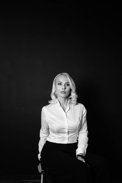 Portret van een blonde vrouw in een wit overhemd - Foto, afbeelding
