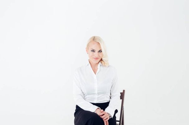 Portrait of a blonde woman in a white shirt and black pants - Foto, Imagen