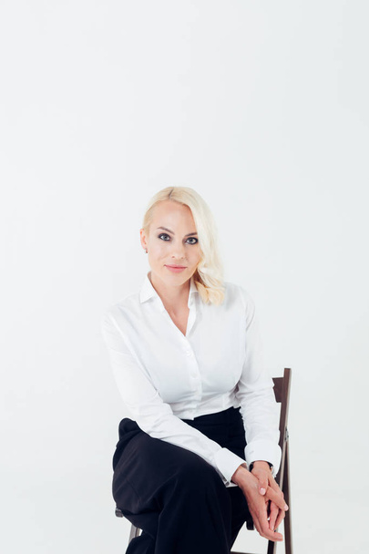Portrait d'une femme blonde en chemise blanche et pantalon noir
 - Photo, image