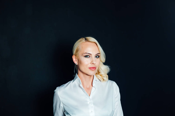 Portret van een blonde vrouw in een wit overhemd - Foto, afbeelding