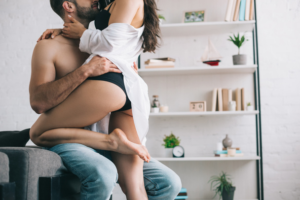 cropped view of shirtless man hugging with sexy woman in shirt  - Foto, imagen