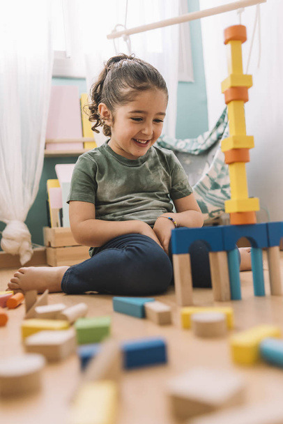 happy girl building with colorful wooden blocks - Fotografie, Obrázek