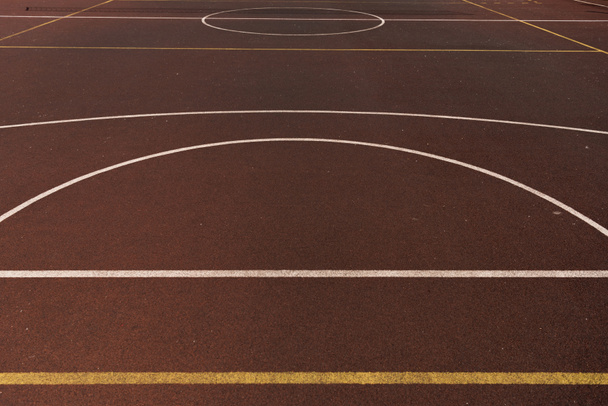 баскетбольная площадка с желтыми и белыми линиями на коричневой игровой поверхности
 - Фото, изображение