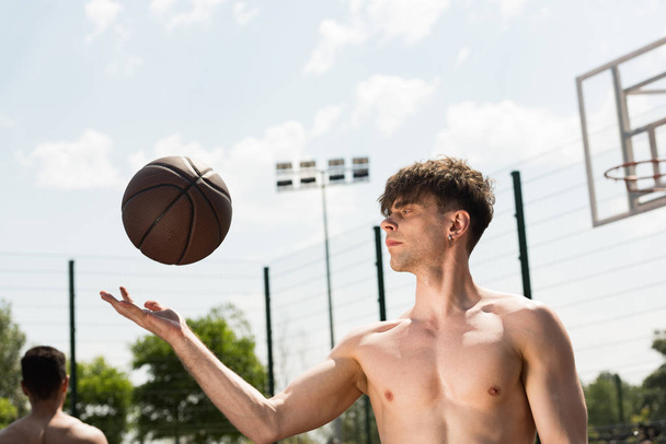 shirtless basketball player with ball at basketball court in sunny day - Foto, Imagem