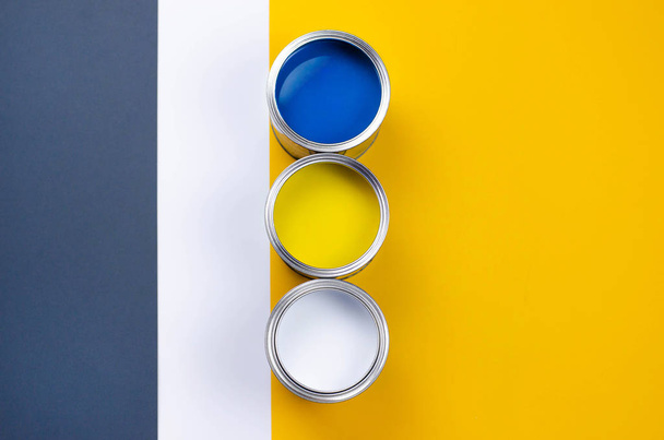 Three cans of multicolored paint on a gray-orange with a white background. - Fotografie, Obrázek