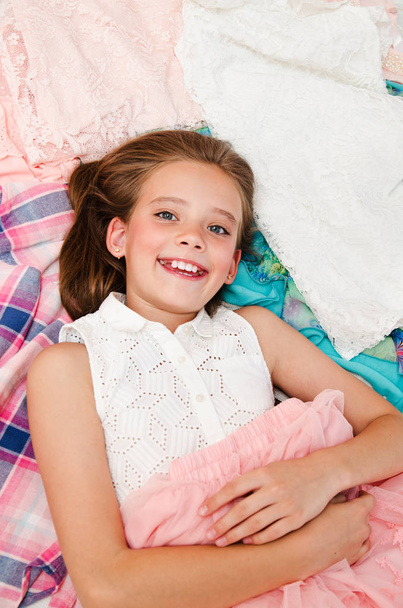 Portrait of smiling happy little girl child schoolgirl lying on  - Foto, immagini