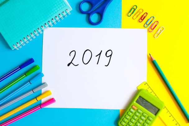 Top view of 2019 PLAN text on white paper note with business office accessories.Top view.Copy space. School office supplies.Creative desk with colourful stationery.Colored paper clip.Planning concept. - Photo, Image