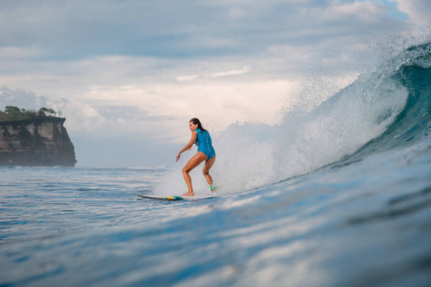 Chica de surf en la tabla de surf. Mujer en el océano durante el surf. Surfista y ola
 - Foto, imagen
