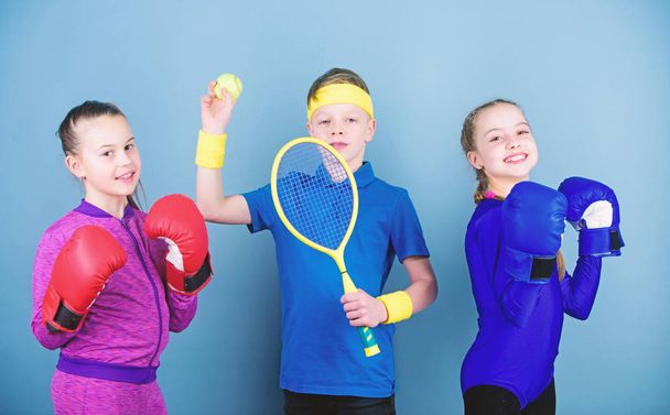 Child might excel completely different sport. Sporty siblings. Girls kids with boxing sport equipment and boy tennis player. Ways to help kids find sport they enjoy. Friends ready for sport training - Fotografie, Obrázek