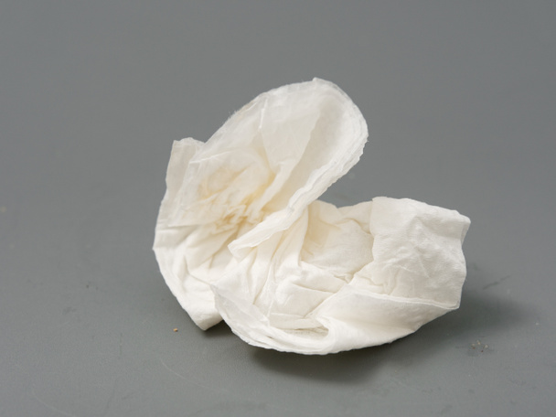 servilleta de papel blanco usada arrugada sobre un fondo gris
 - Foto, imagen
