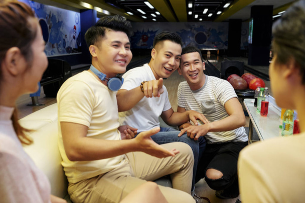 Βιετναμέζοι νέοι αστεία και γέλια όταν ξεκουράζονται στο tablet στο μπόουλινγκ κλαμπ - Φωτογραφία, εικόνα