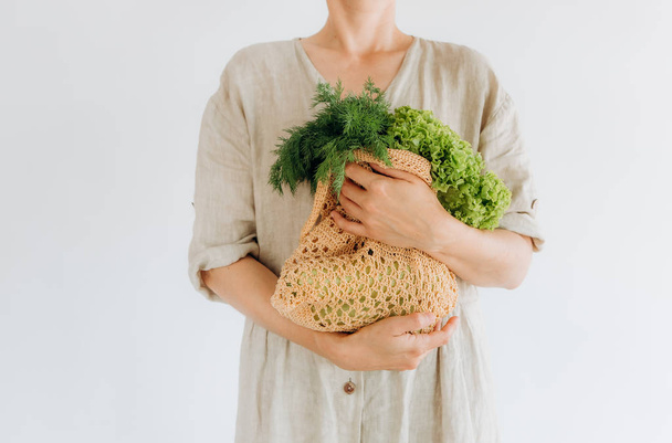 woman hugs food greens shopping bag mesh - Foto, Imagem