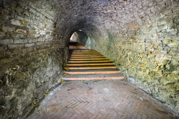 Нови-Сад, Сербия 13 июня 2019 года: вверх по лестнице через туннель. Каменная лестница на башню с часами в крепости Нови-Сад-Петроварадин, Сербия
 - Фото, изображение