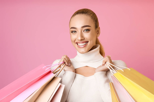 ハッピーショッピング。カラフルなバッグを持つ女の子, ピンクの背景 - 写真・画像