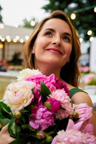 Beautiful young woman with bouquet of fresh peonies  - Foto, afbeelding