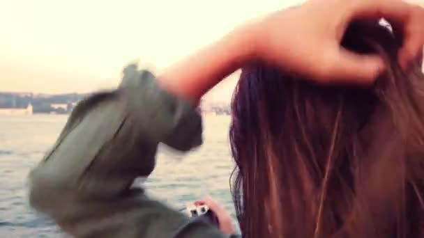 Piękna młoda dziewczyna bierze zdjęcie podczas rejsu statkiem z widokiem na Bosfor i zabytki w Stambule, Turcja. - Materiał filmowy, wideo