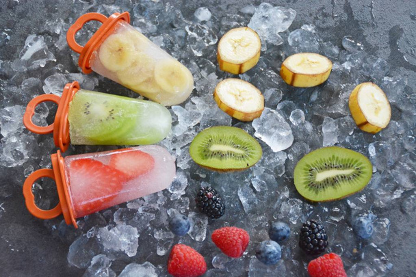 gelo de frutas com pedaços de frutas em cubos de gelo
  - Foto, Imagem