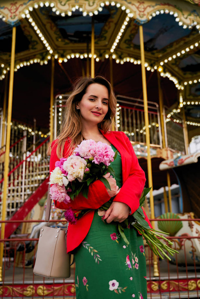 Beautiful young woman with bouquet of fresh peonies  - Foto, Bild