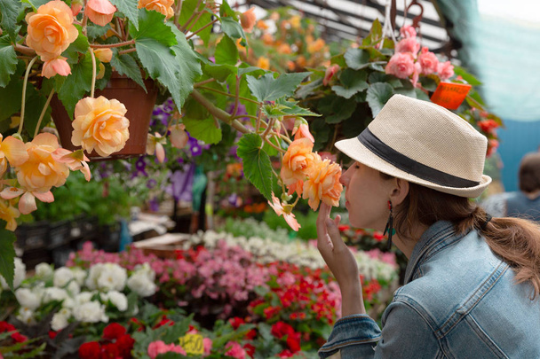 Young woman shopping in an outdoors fresh urban flowers market,  - 写真・画像