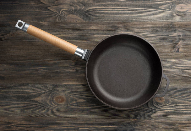 Cast iron pan on rustic wooden  background, top view - Foto, immagini