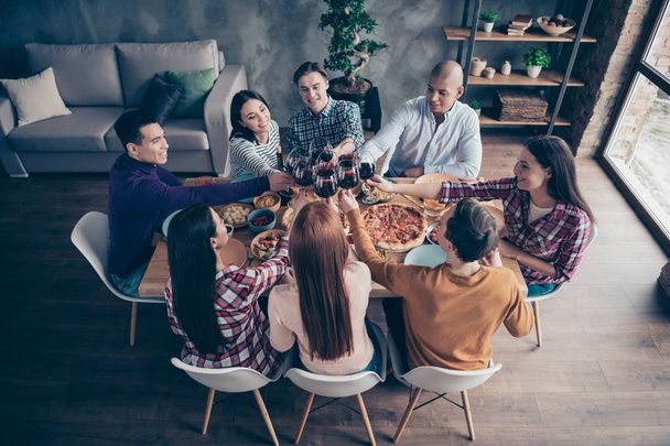 Close up top above high angle photo company social crowd event hang out members buddies different race raise glasses beverage sit round table shirts formal-wear sweaters pullovers loft room indoors - 写真・画像