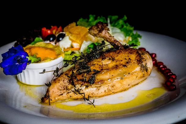 francuski kurczak najwyższy grillowany kurczak z gratin ziemniaczanych i owoców salsy i granatu nasion i liści grochu motyl - Zdjęcie, obraz