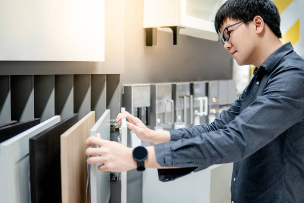 Asian man choosing cabinet or countertop materials - Photo, Image