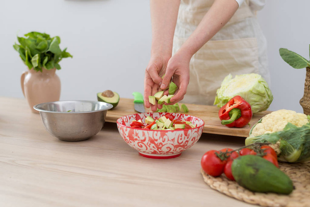 A woman makes a salad of fresh vegetables. Vegetarian, healthy food. - Foto, Imagem