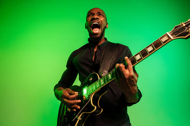 junger afrikanisch-amerikanischer Jazzmusiker spielt Gitarre - Foto, Bild