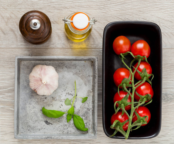 Vista superior yacía plana Comida puesta con tomates aceite de albahaca de ajo y pimienta
 - Foto, Imagen