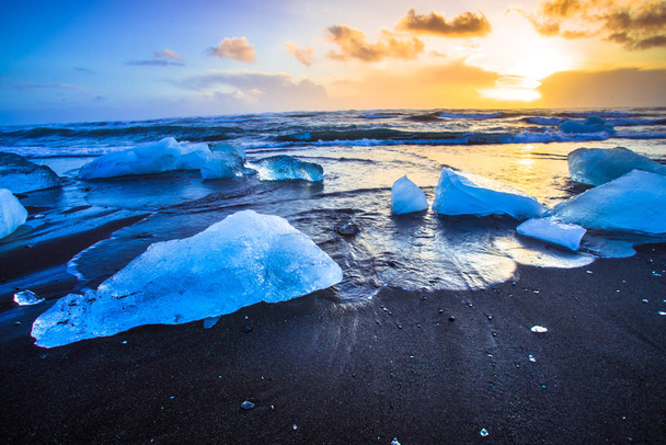 Ice rock with black sand beach at Jokulsarlon beach (Diamond beach) in southeast Iceland - Zdjęcie, obraz