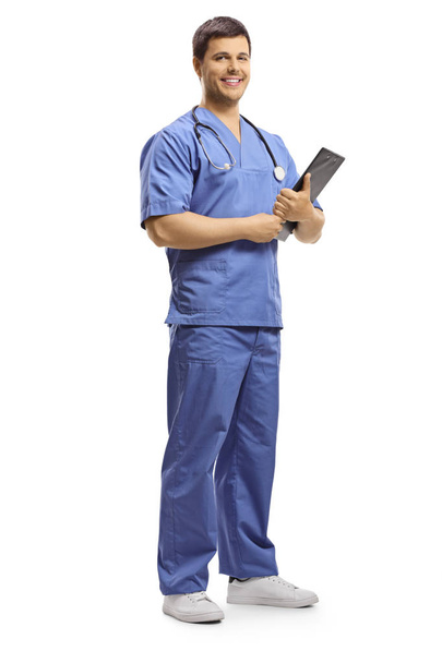Smiling young doctor posing and holding a clipboard - Foto, immagini