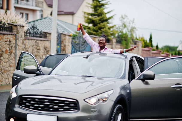 Rich business african woman in silver suv car on sunroof having  - Valokuva, kuva