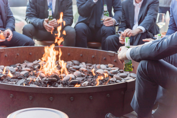 Businesspeople hangout near patio fire pit at wintertime in Chicago, America - Photo, Image