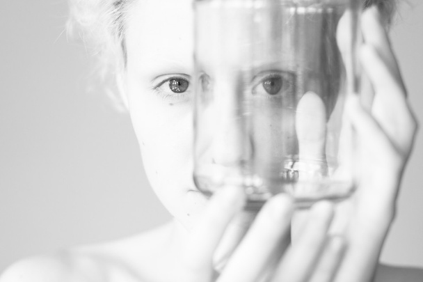 Abstract picture - the girl looks through the empty jar (black and white photo) - Photo, Image