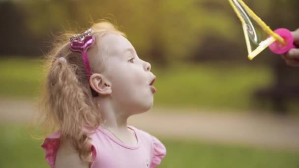 Zelfverzekerde speelse kleine schattige meid waait enorme lucht zeep Bubble blower medium close-up - Video