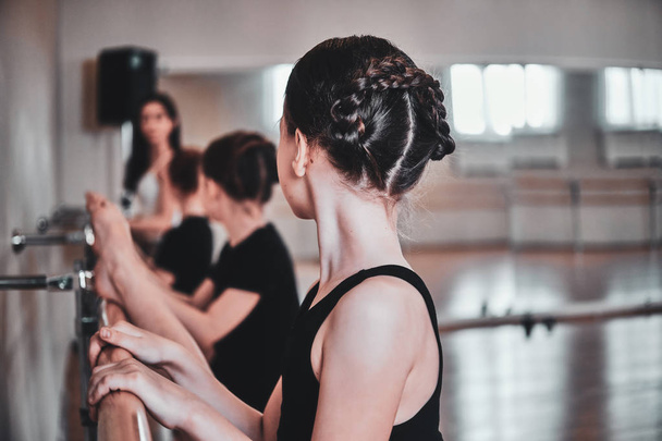 Training of young ballerinas at big light hall with mirror - Фото, зображення
