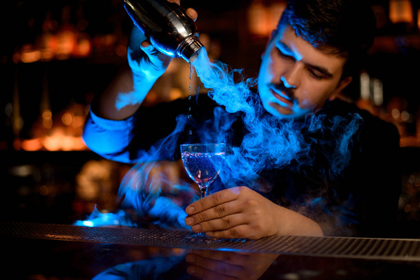 Μπάρμαν που χρησιμοποιεί σέικερ για να προετοιμάσει ένα αλκοολούχο ποτό - Φωτογραφία, εικόνα