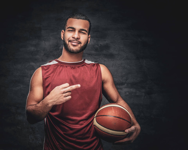 A black man holds a basket ball. - Φωτογραφία, εικόνα