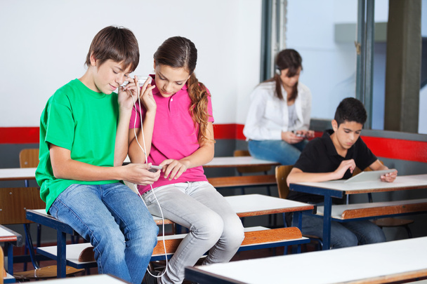 Écoliers adolescents écoutant de la musique en classe
 - Photo, image