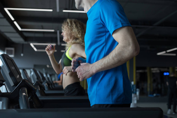 Couple running on treadmill in gym, - Фото, зображення
