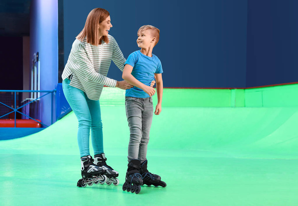 Woman teaching her son roller skating at rink. Space for text - Fotoğraf, Görsel