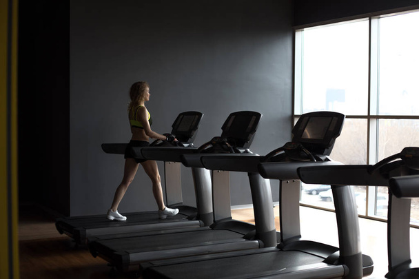 Sport woman is running on treadmill in gym, - Fotoğraf, Görsel